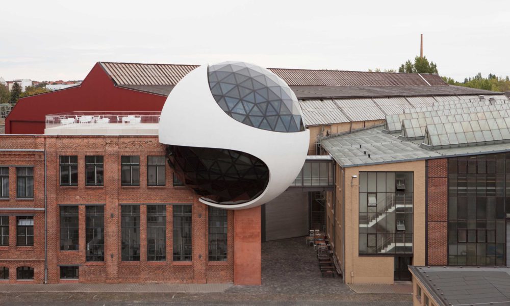 Pequeños focos orientables están integrados en la parte superior del tabique e iluminan la carcasa interior de hormigón, que actúa como un reflector blanco. Pequeños focos adicionales se encuentran en el conducto de ventilación del piso negro a lo largo del perímetro de la esfera, directamente al lado de la construcción de vidrio-acero, para lavarlos suavemente con luz indirecta.